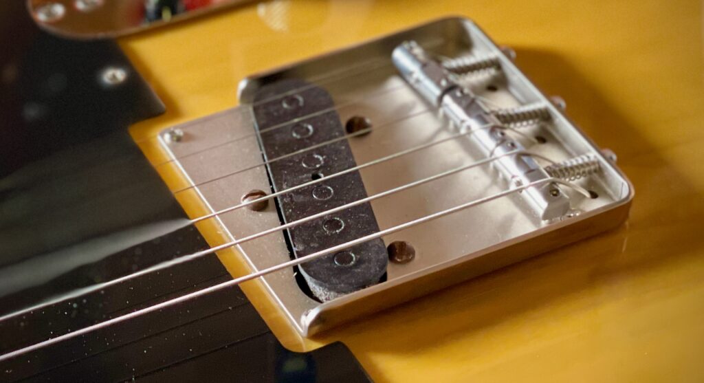 This photo shows the Seymour Duncan Antiquity Tele bridge pickup, fitted to my Squier Esquire known as The Squirrel.

We can see that the pickup has six flat pole pieces (ie no raised pickup poles at all), in a black bobbin.

The pickup has been distressed to make it look old. So have the screws that came with the pickup.