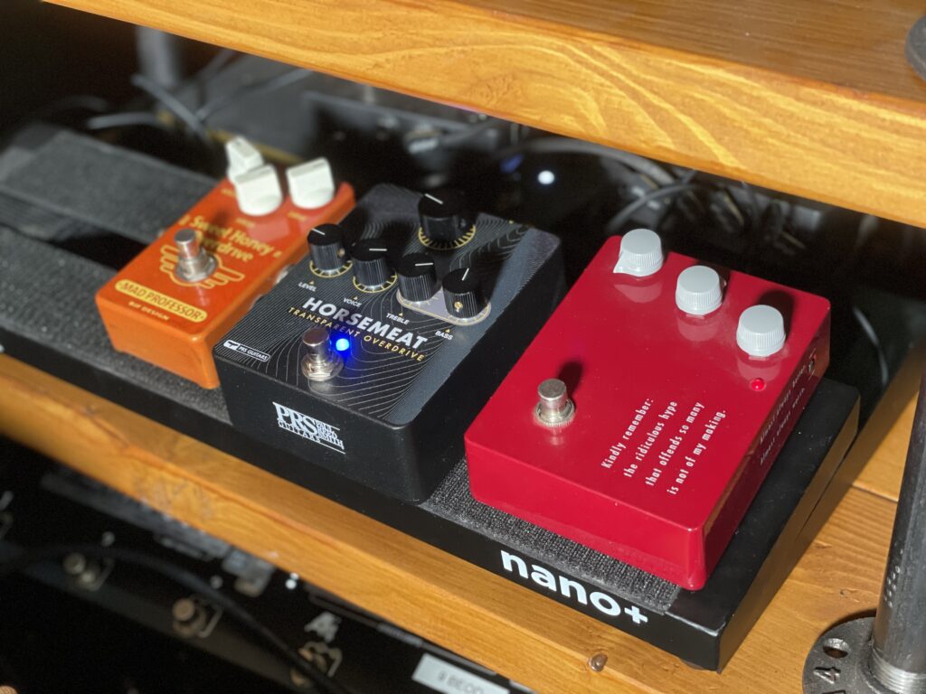 This is a photo of my pedal board at home. 

There are three guitar overdrive pedals on the board, all closely nestled together. 

We've got the tasteful orange of the Sweet Honey Overdrive on the left. In the middle, the clean, modern, almost futuristic look of the PRS Horsemeat. And on the right, the (almost subtly) understated Klon KTR. 

Understated, except for Bill Finnegan's famous legend: "Kindly remember: the ridiculous hype that offends so many is not of my making."