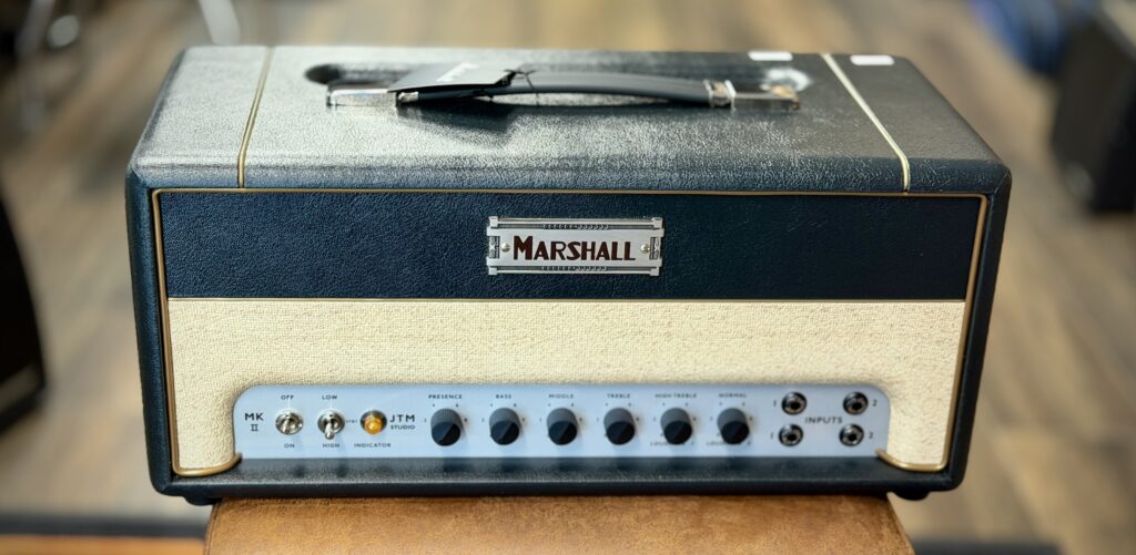 This is a photo of my Marshall Studio JTM 20 ST20H amplifier head.
The photo was taken in the shop that I bought it from, while we were setting up to test that the amp wasn't DOA.
The photo shows the front of the amplifier head.
The Studio JTM has a distinctive look, thanks to Marshall's use of its original "coffin" logo, a cream-coloured basket-weave fabric for covering the front panel, and deep black control knobs.