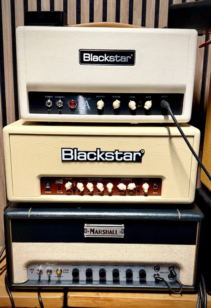 This is a photo of three guitar amplifier heads, stacked on top of each other.

On top is the Blackstar TV-10A amp. In the middle of the stack is the Blackstar Debut 100RH amp. And on the bottom of the stack is the Marshall JTM Studio amp.

It's quite striking how much smaller the Blackstar TV-10A amp is. It's maybe 80% of the width of the other two amps, making it very compact.

The TV-10A also features a very white tolex, which is quite a contrast to Blackstar's more usual cream tolex used on the Debut 100RH and many of their older amps.